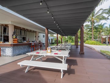 a covered patio with tables and chairs