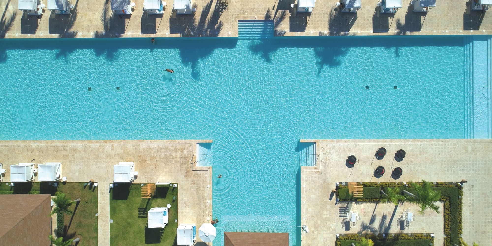 a swimming pool with tents and trees