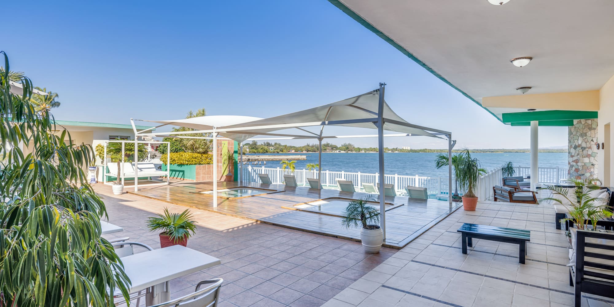 a patio with a large pool and chairs and a large deck