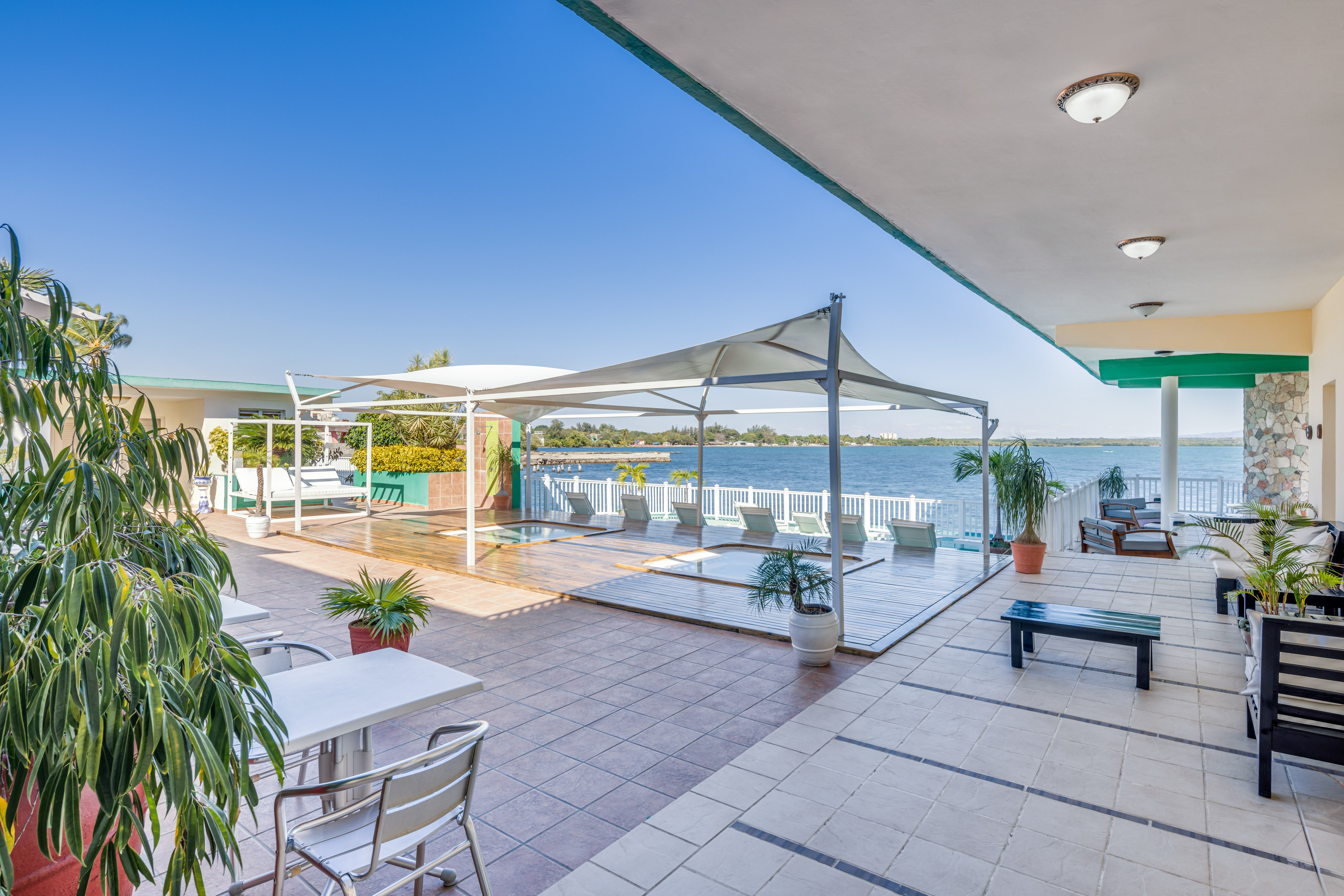 a patio with a large pool and chairs and a large deck