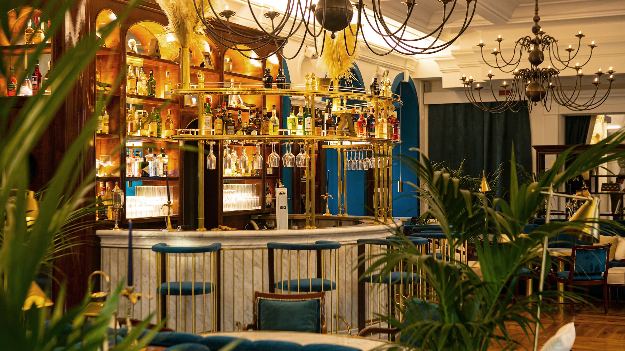 a bar with a chandelier and shelves of wine glasses