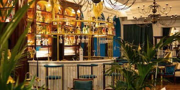 a bar with a chandelier and shelves of wine glasses