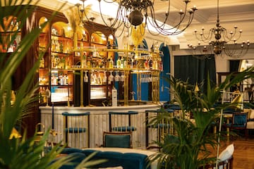 a bar with a chandelier and shelves of wine glasses