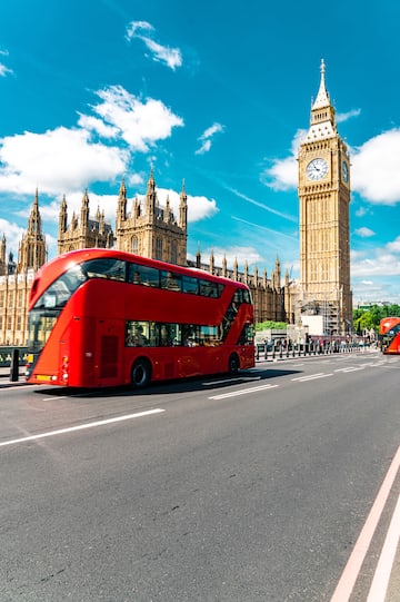 a double decker bus on a street in front of a clock tower