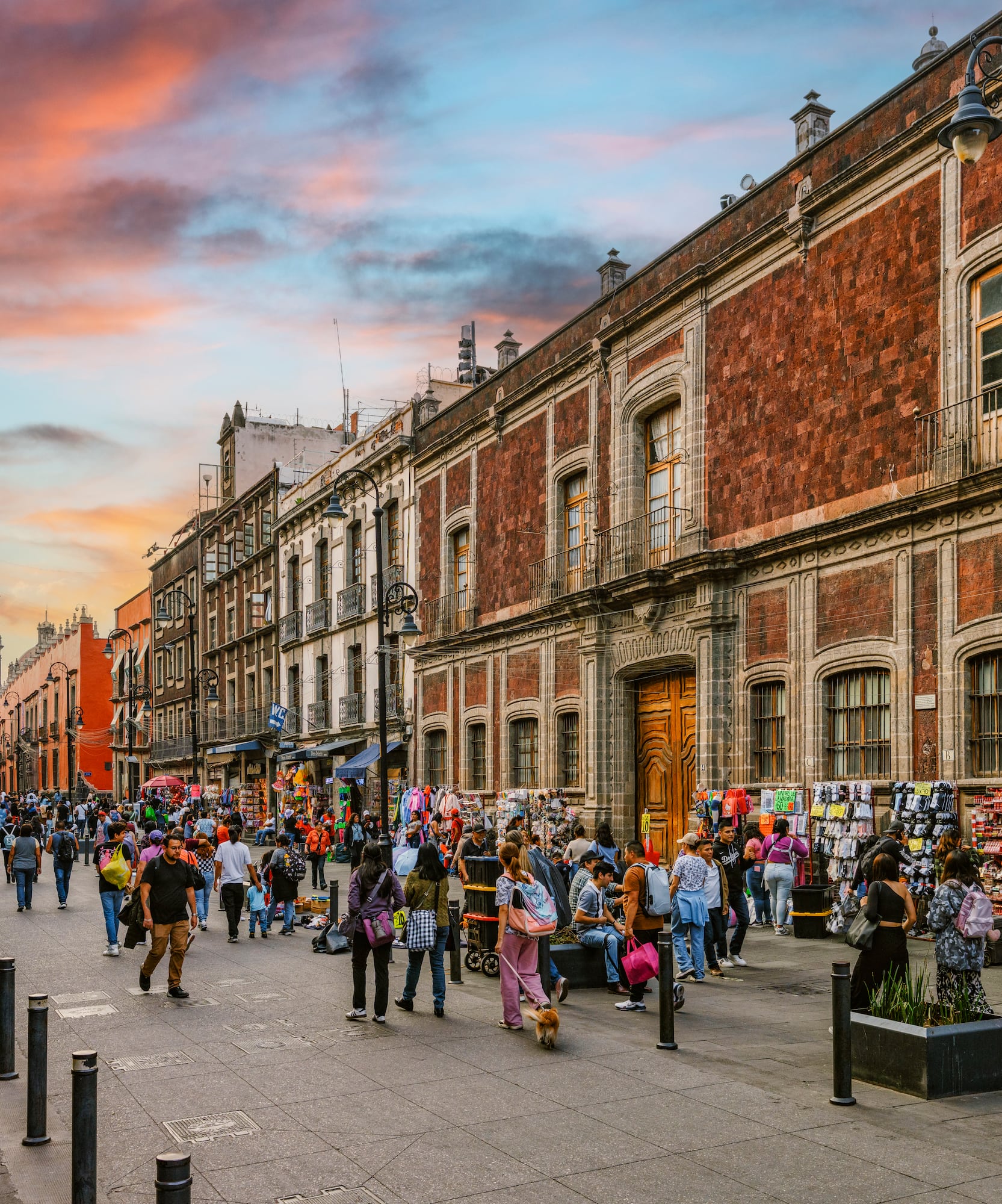 Calle concurrida en CDMX, edificios históricos, Catedral, cielo atardecer.