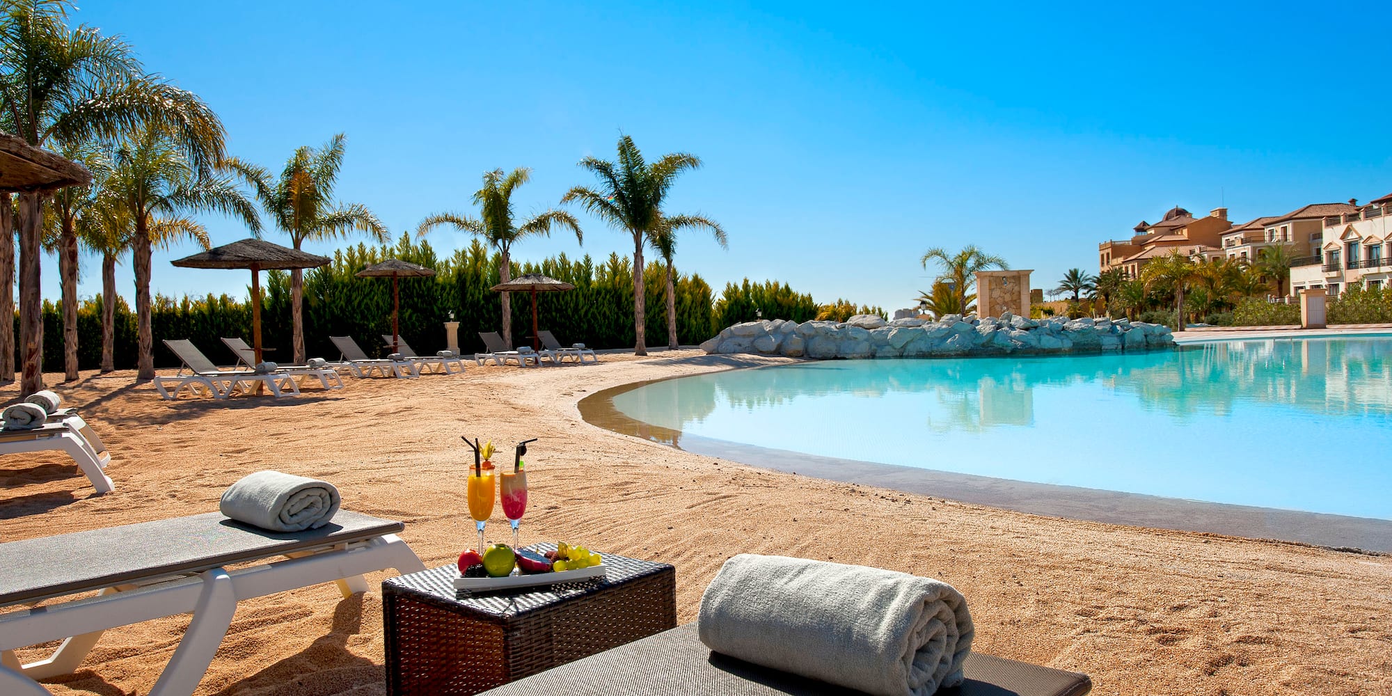 a pool with lounge chairs and drinks on it