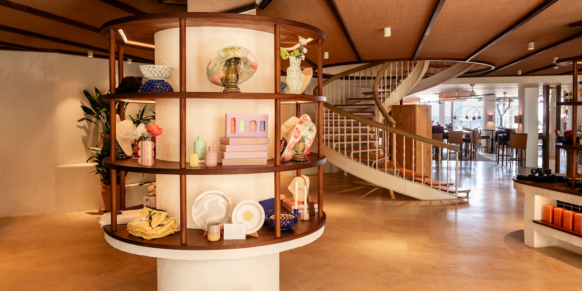 a spiral staircase with a circular shelf with objects on it