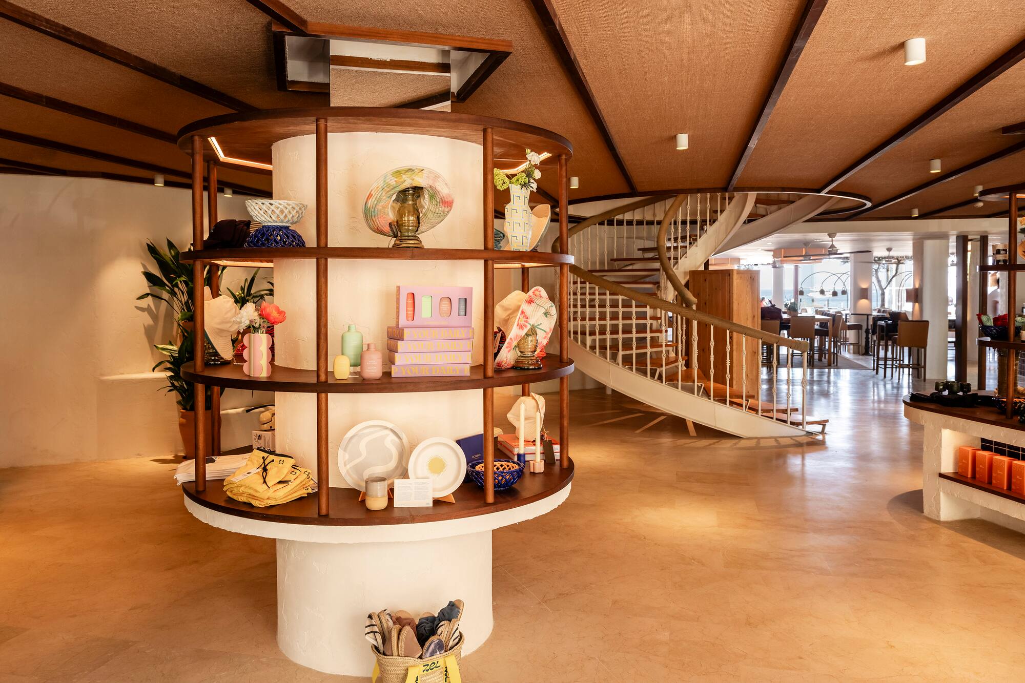 a spiral staircase with a circular shelf with objects on it