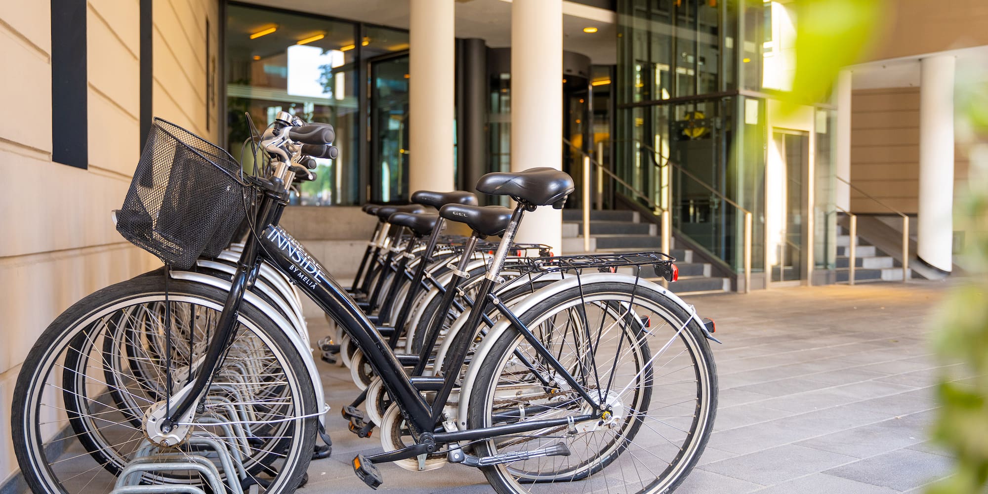 Black Innside by Meliá bicycles parked at a modern hotel entrance.