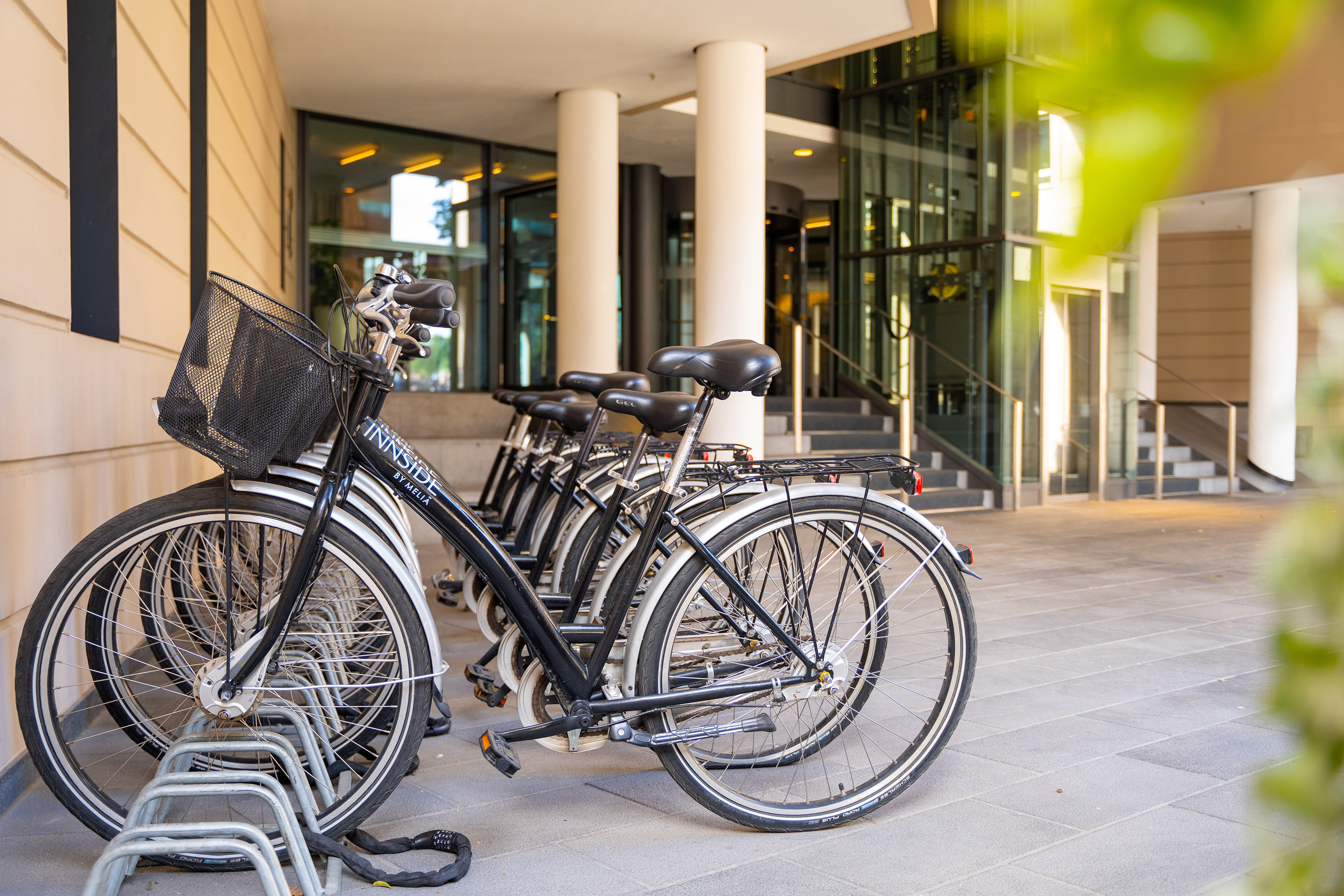 Black Innside by Meliá bicycles parked at a modern hotel entrance.