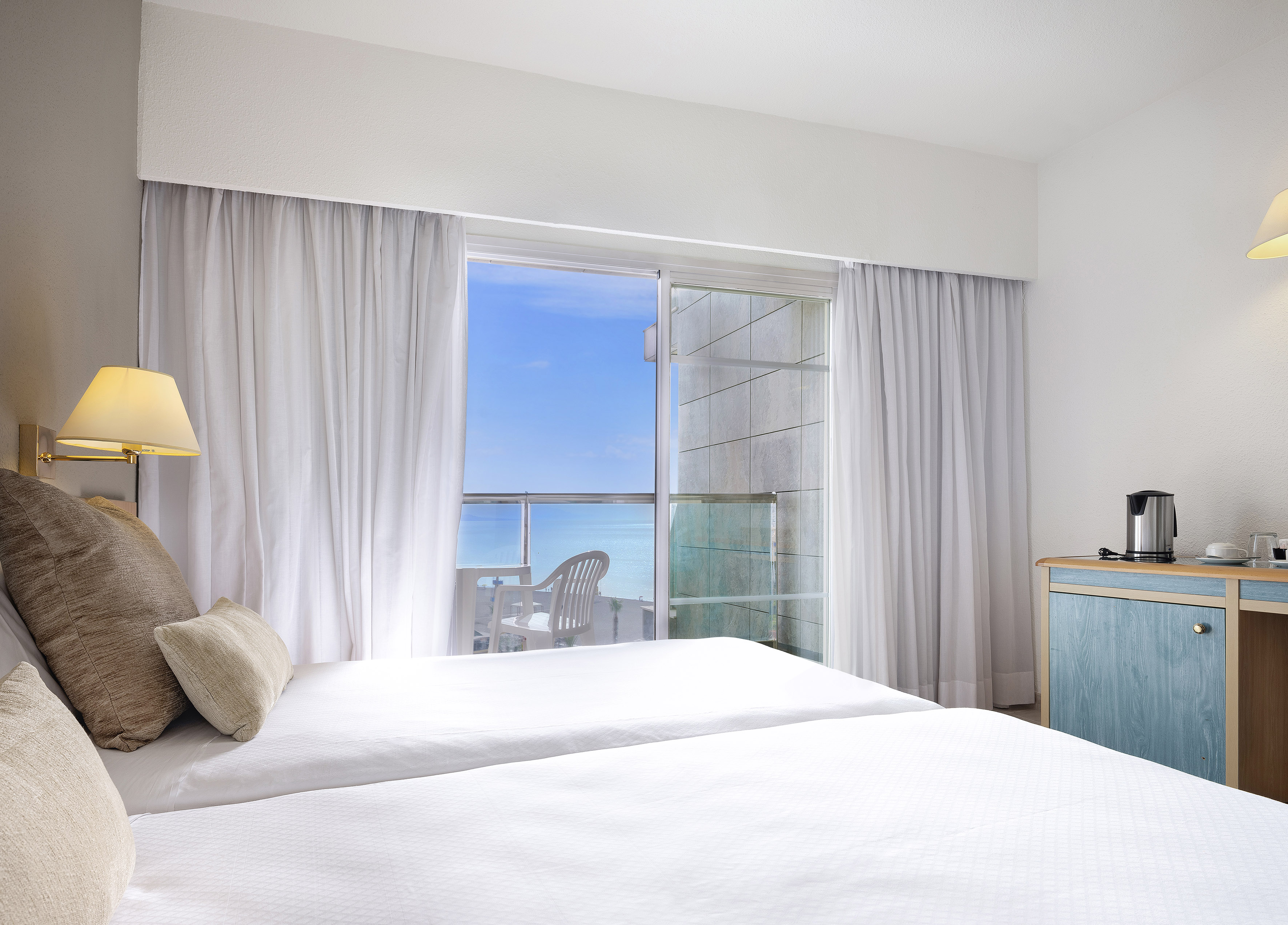 a bedroom with a window and a view of the ocean