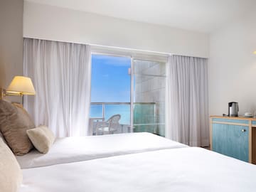 a bedroom with a window and a view of the ocean