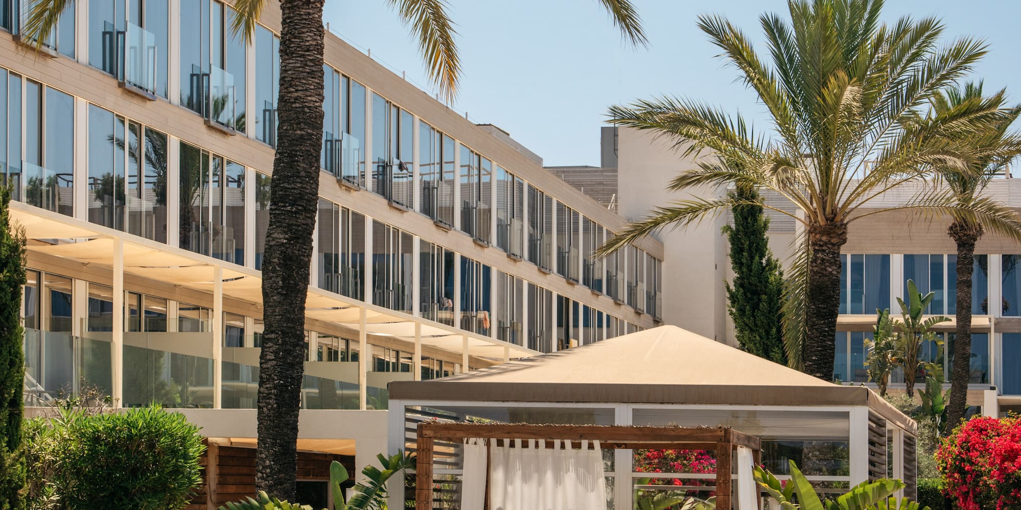 a building with palm trees and a gazebo
