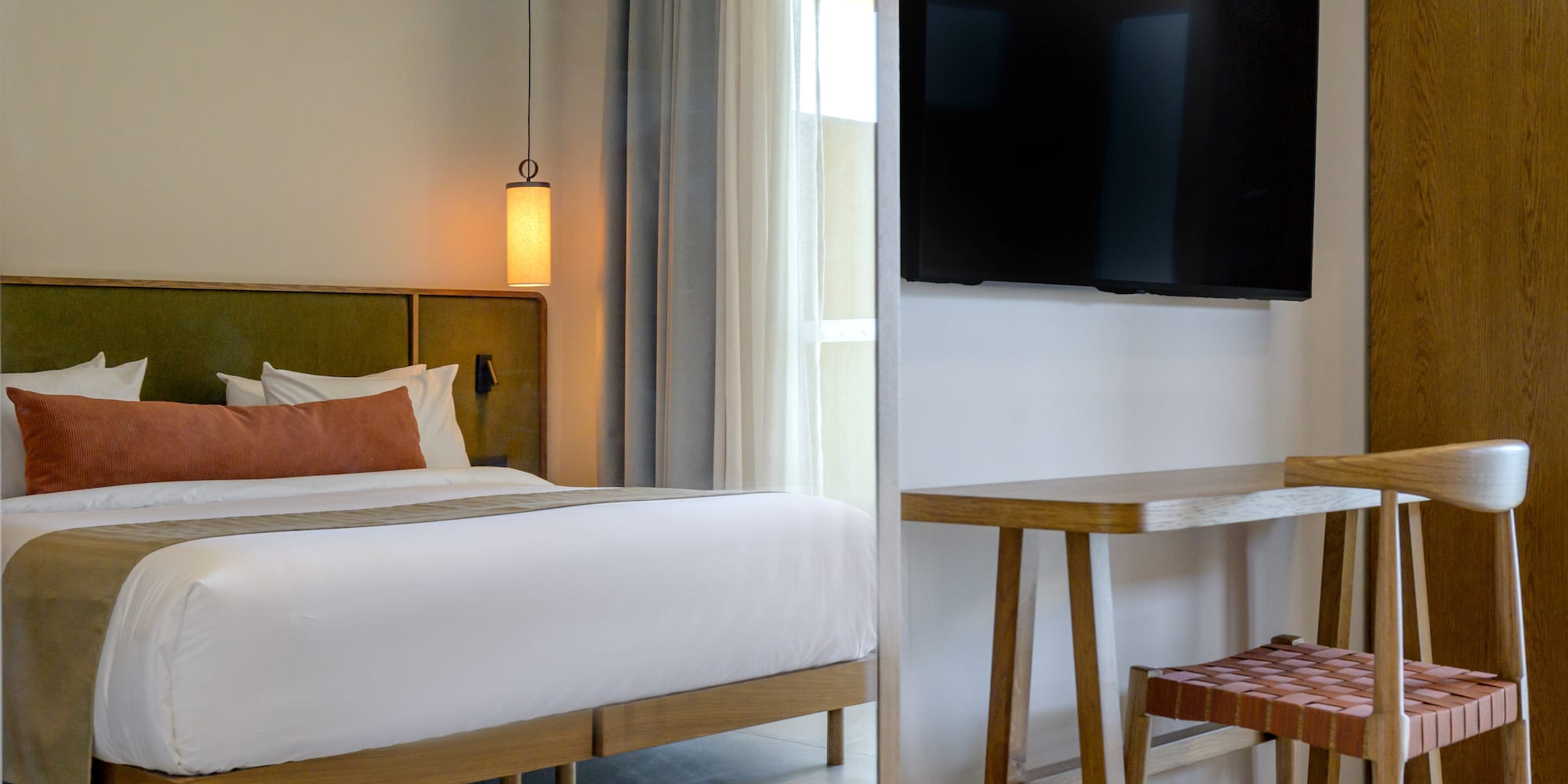 a room with a bed and a television on the wall.