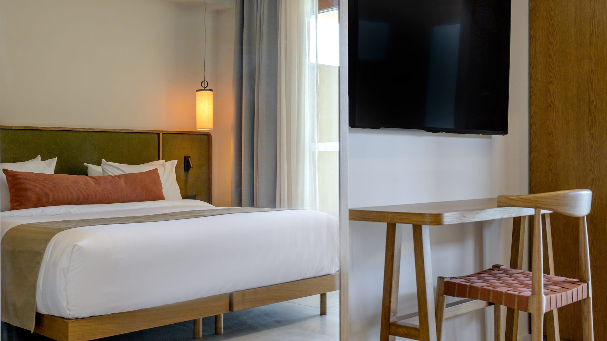 a room with a bed and a television on the wall.