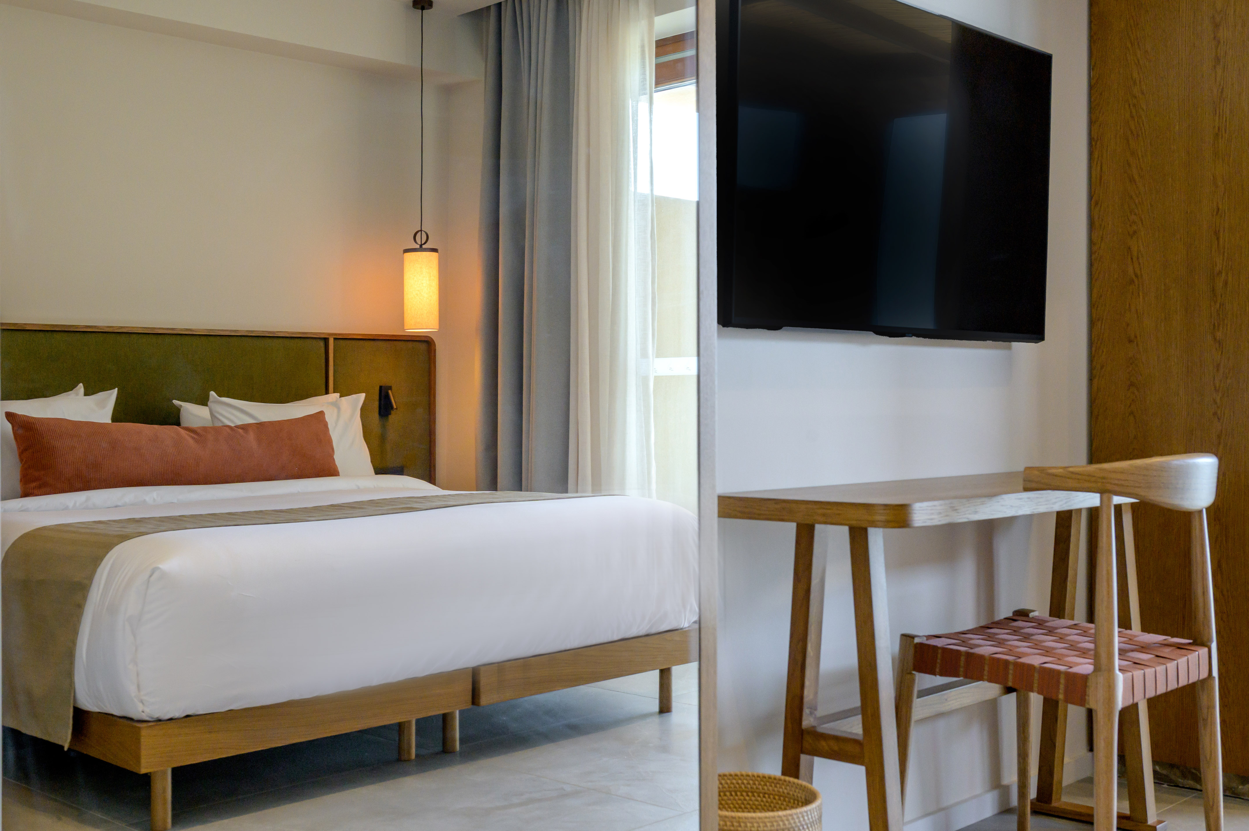 a room with a bed and a television on the wall.