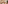 Modern resort lounge with white sofa, colorful books, potted plant, and natural decor.