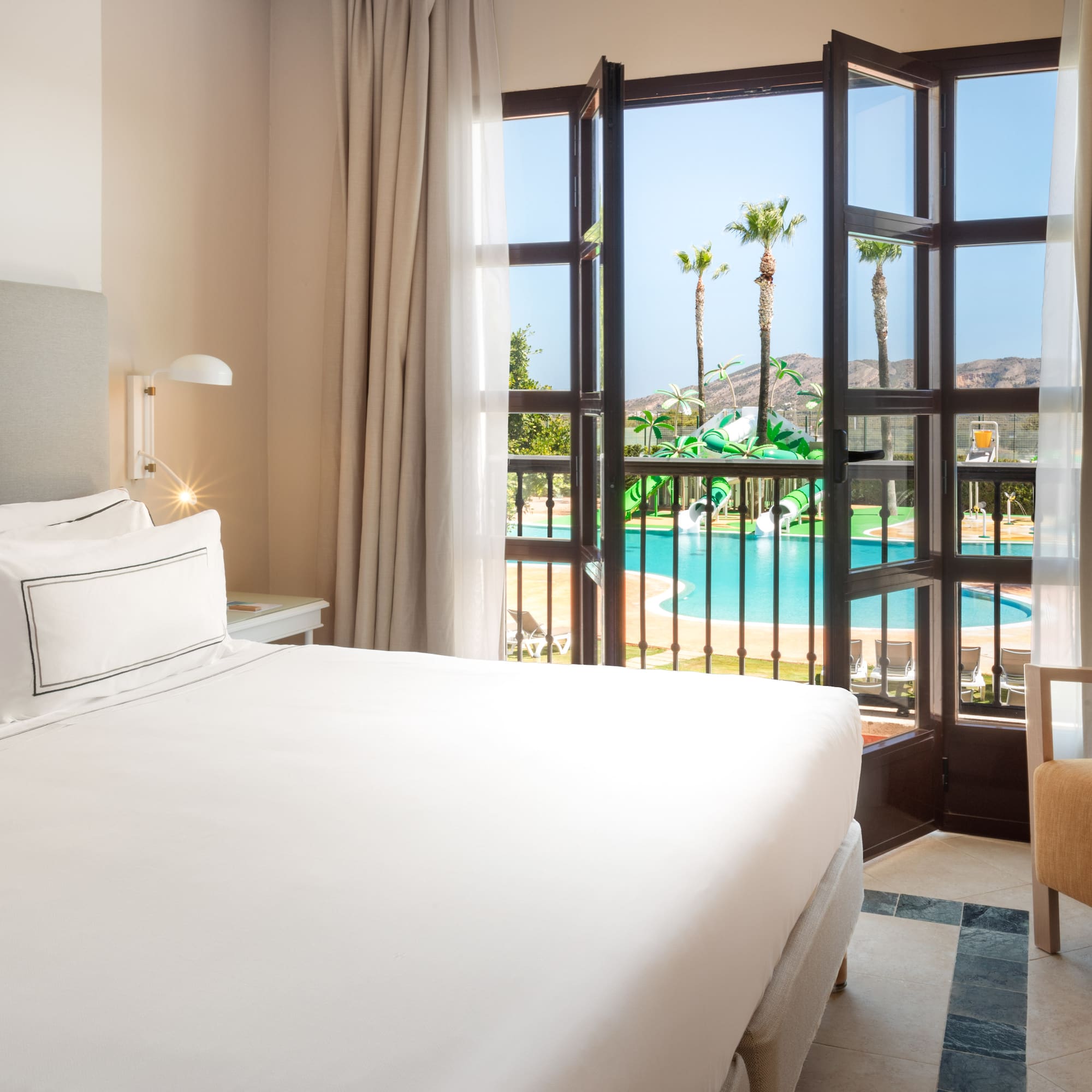 a room with a bed and a pool outside