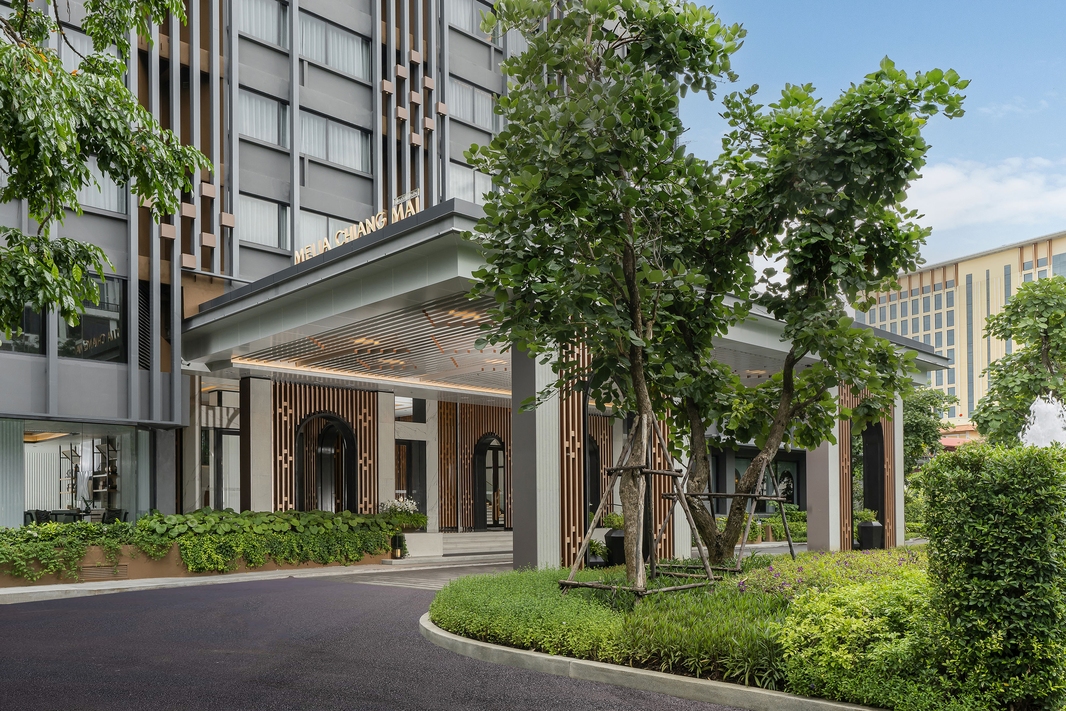 Meliá Chiang Mai hotel entrance, modern design, green landscaping.