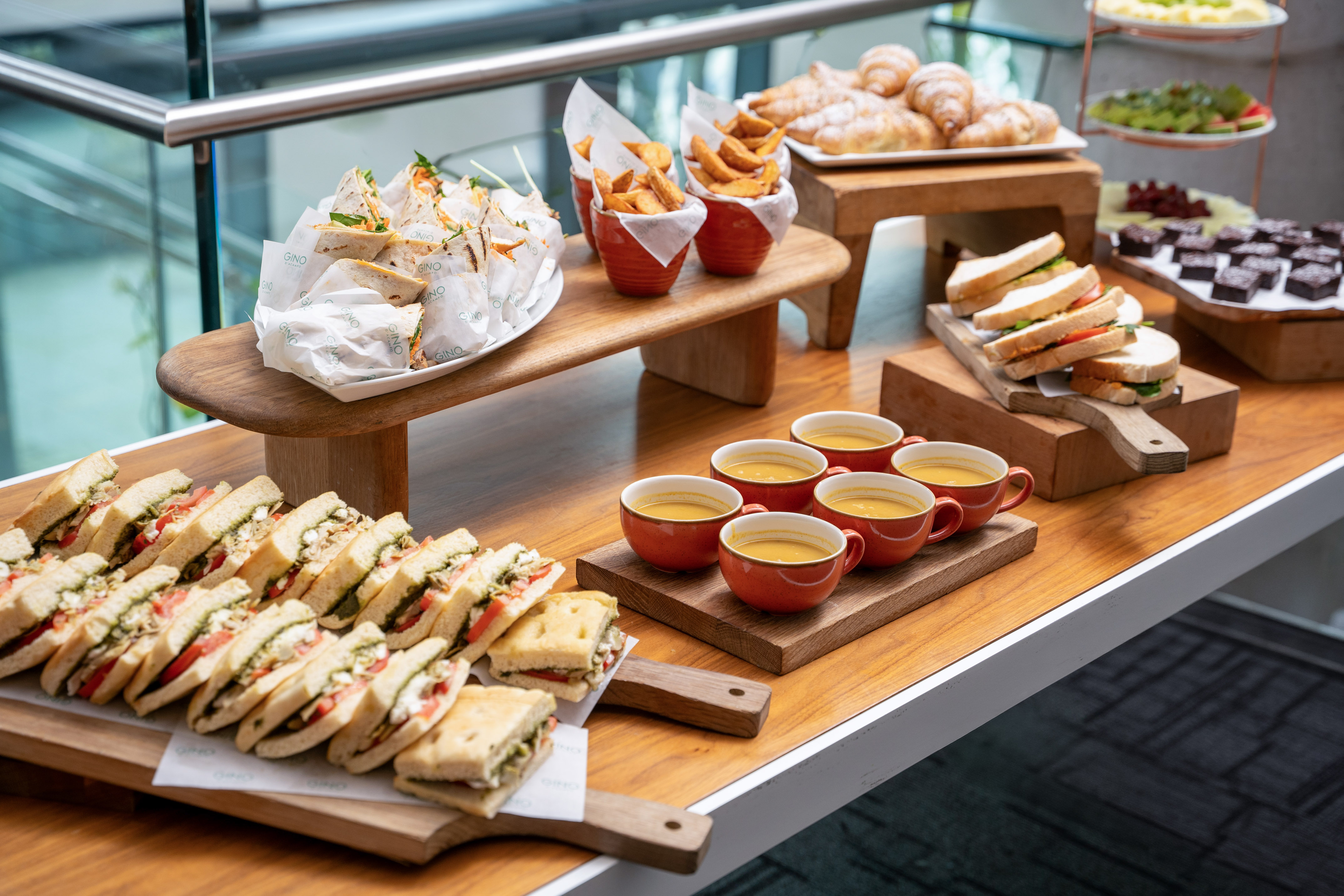 Event lunch buffet: sandwiches, wraps, soup, fries, croissants, and desserts.