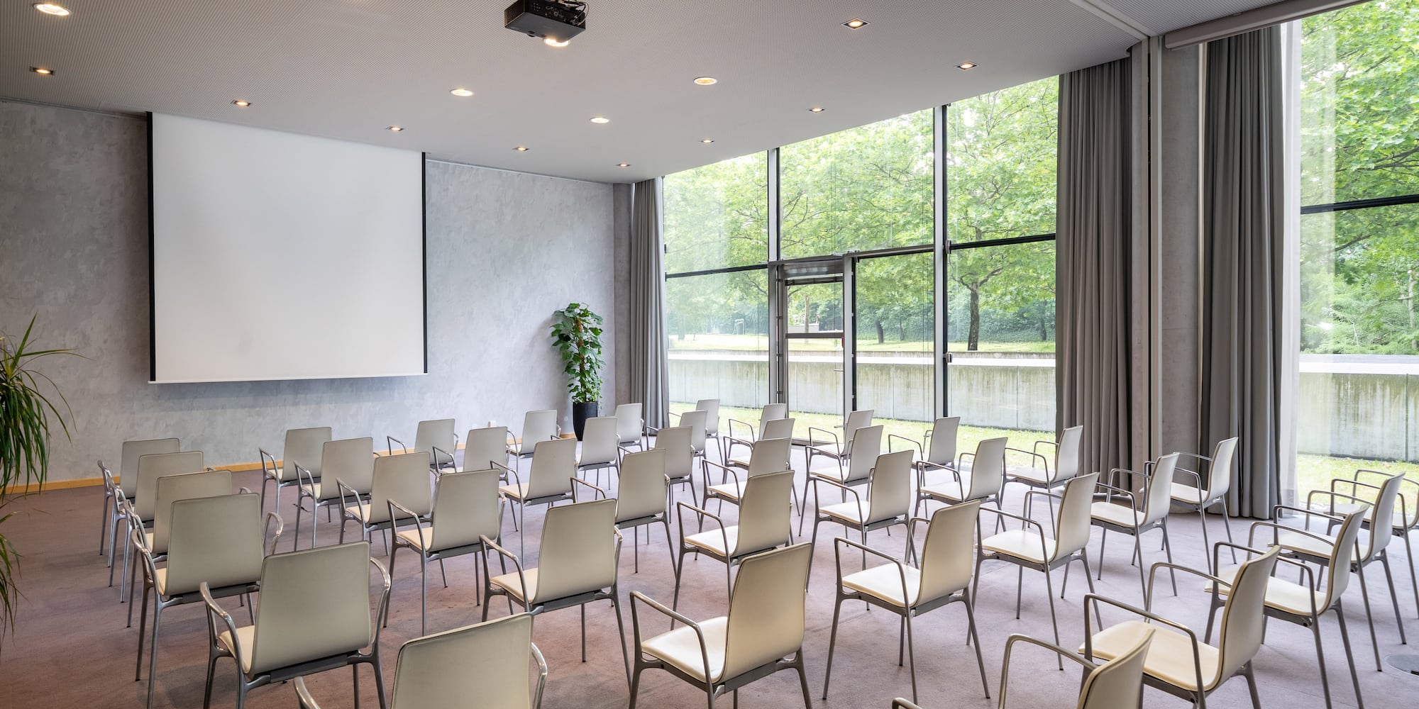a room with white chairs and a projector screen