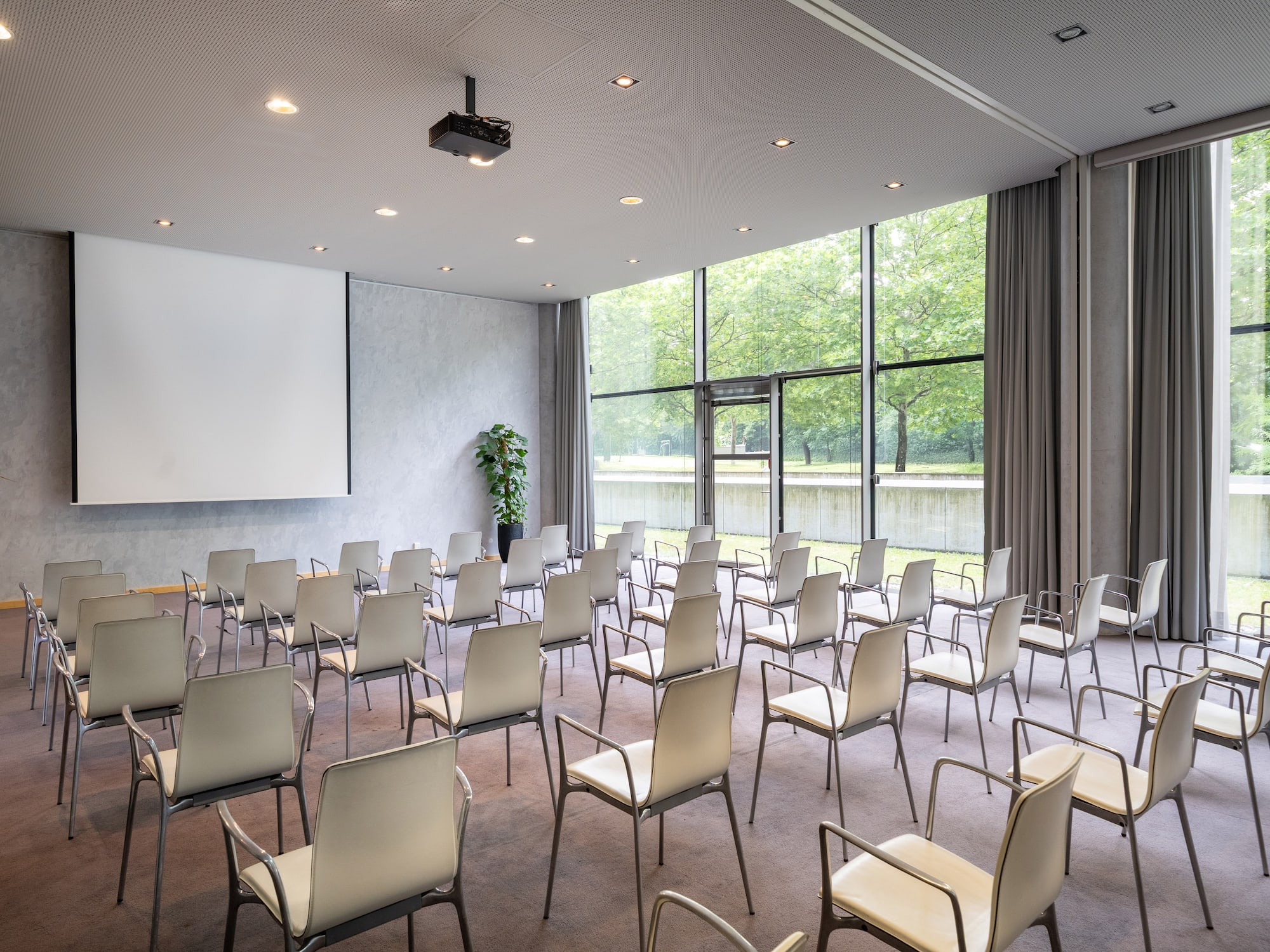 a room with white chairs and a projector screen