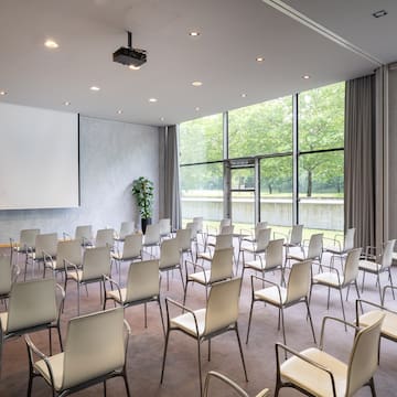 a room with white chairs and a projector screen