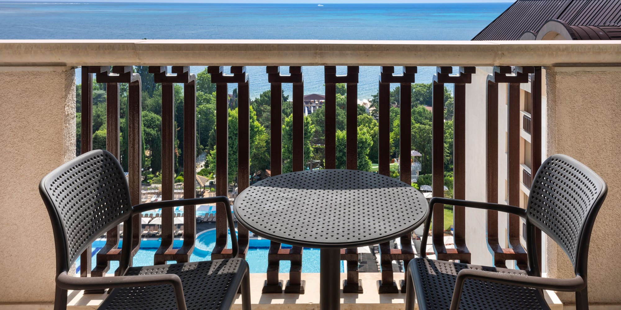 a table and chairs on a balcony overlooking the ocean