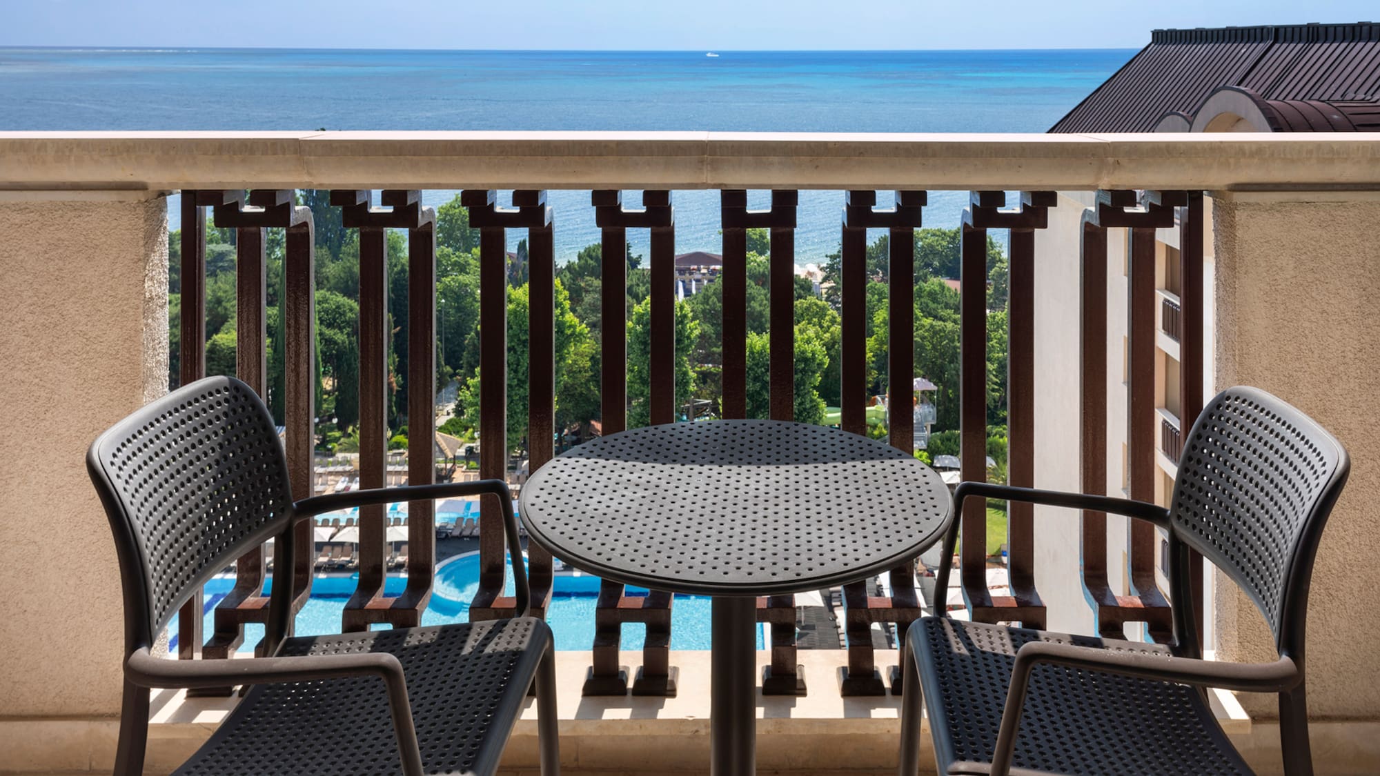 a table and chairs on a balcony overlooking the ocean