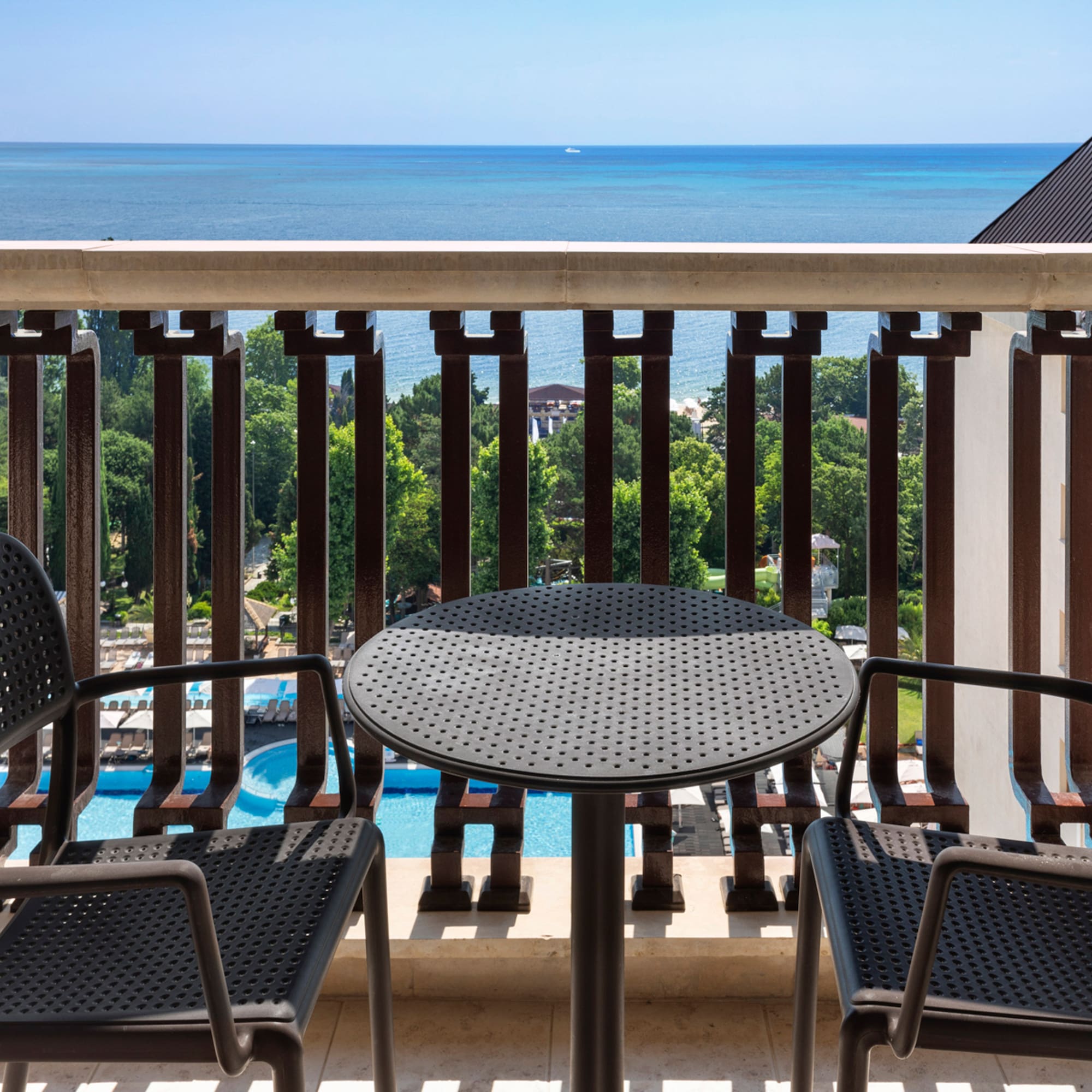 a table and chairs on a balcony overlooking the ocean
