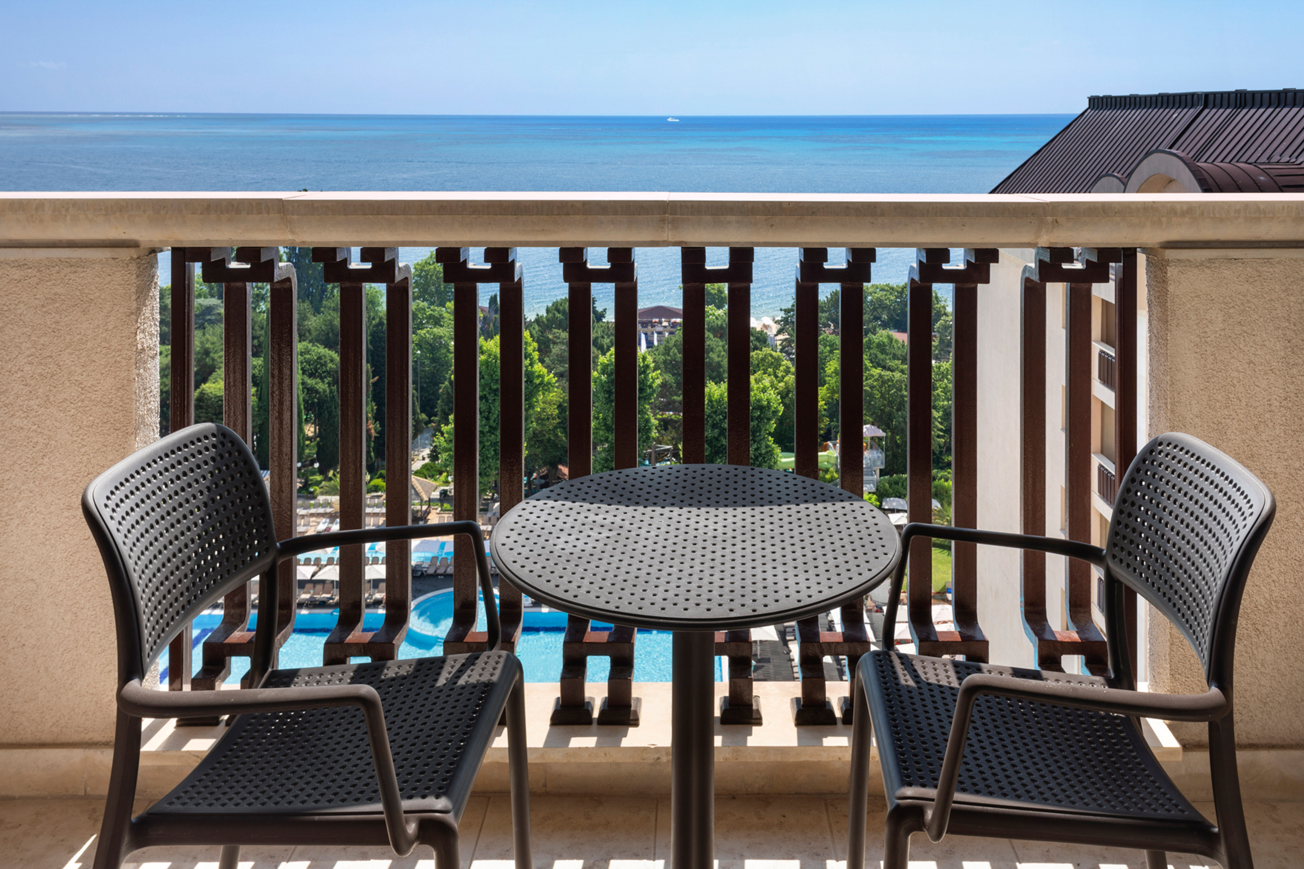 a table and chairs on a balcony overlooking the ocean