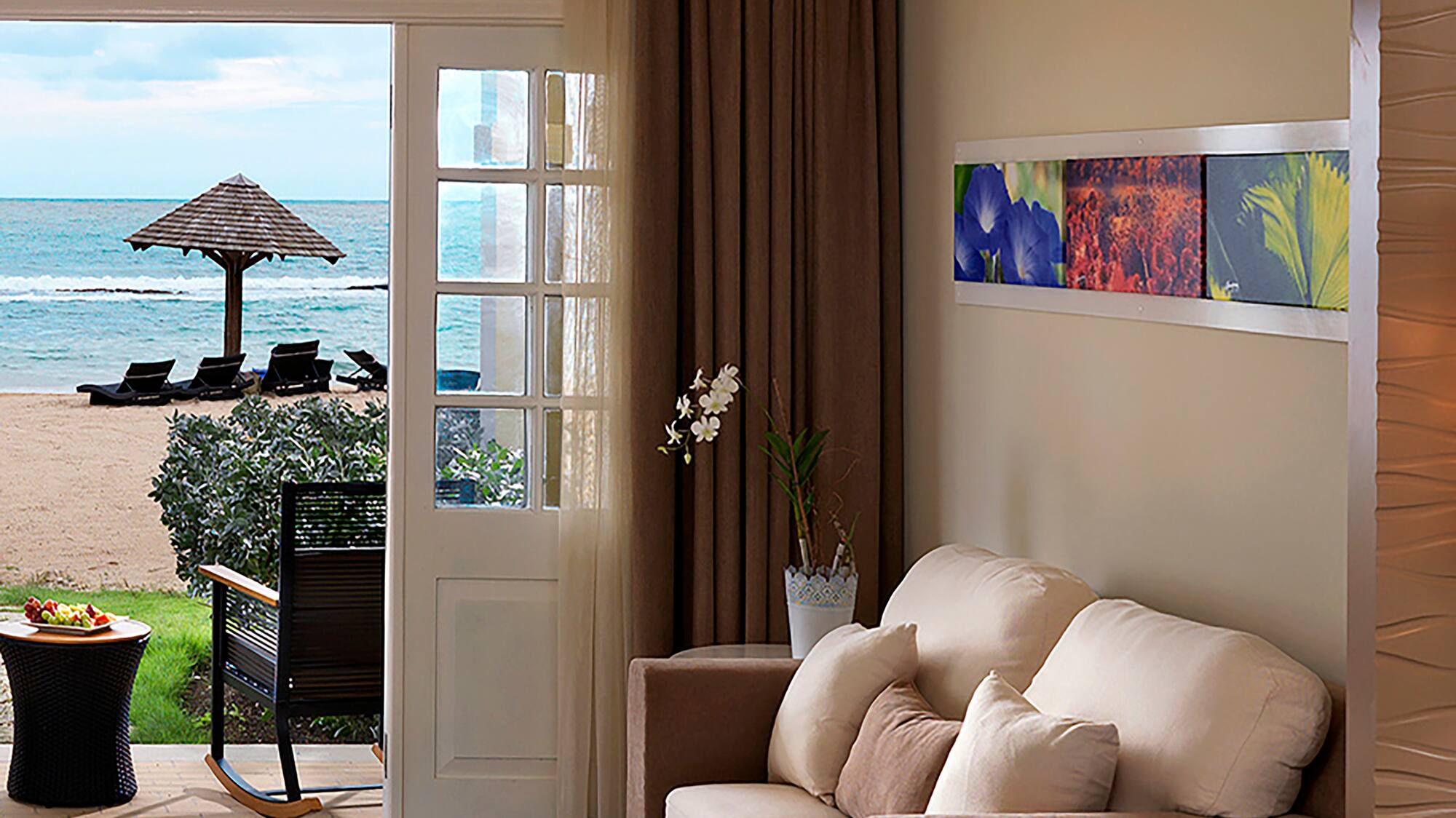 a room with a bed and a couch and a beach view