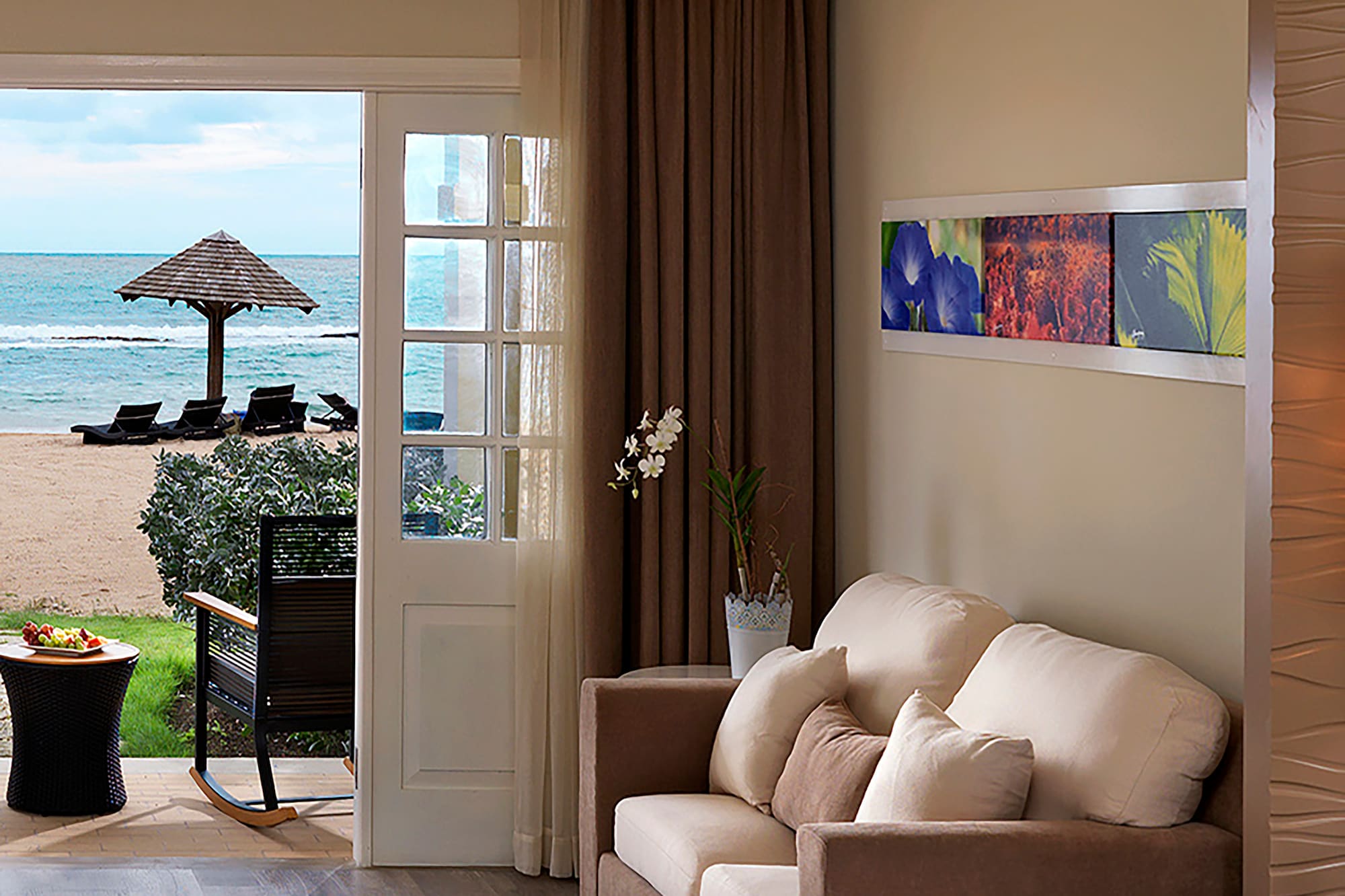 a room with a bed and a couch and a beach view