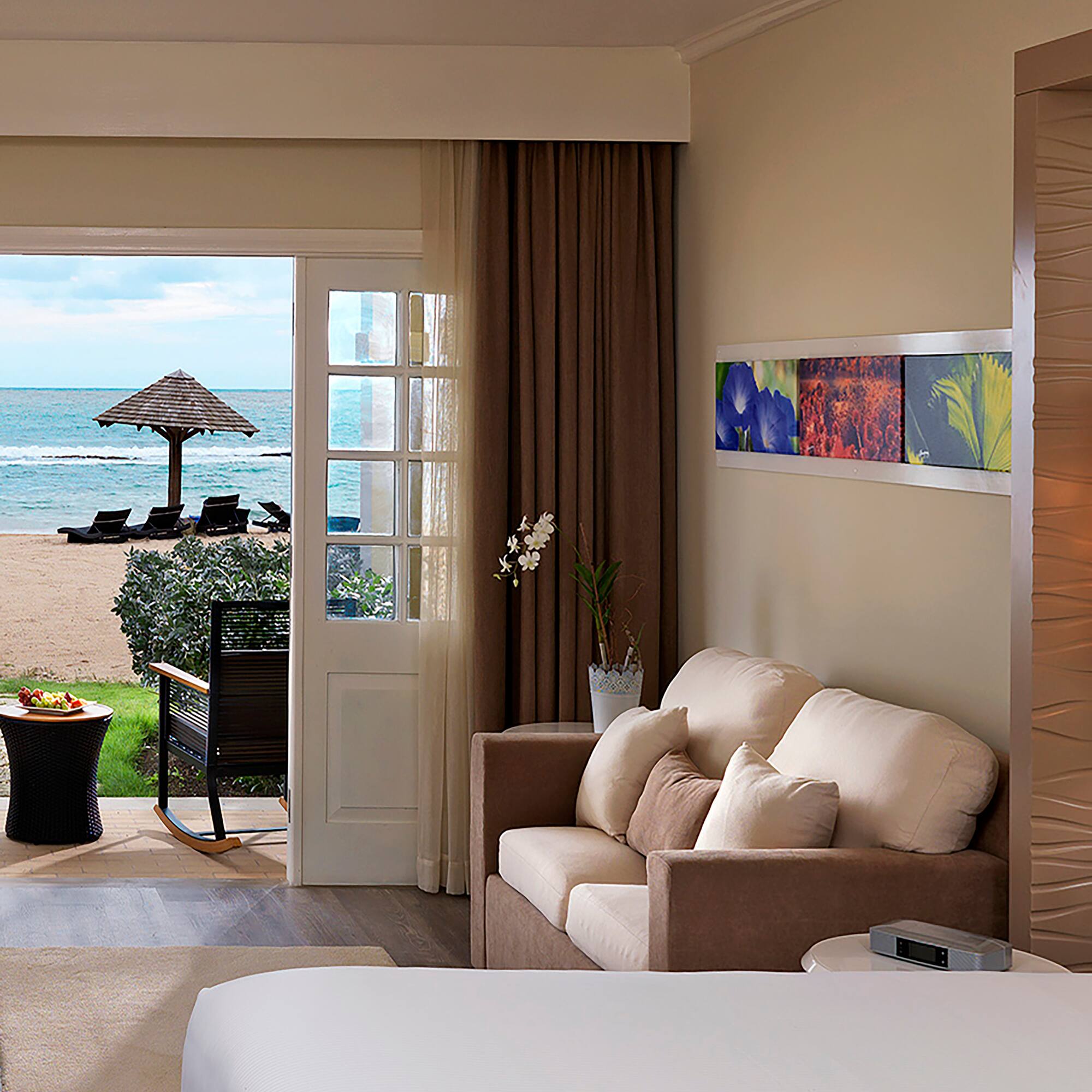 a room with a bed and a couch and a beach view