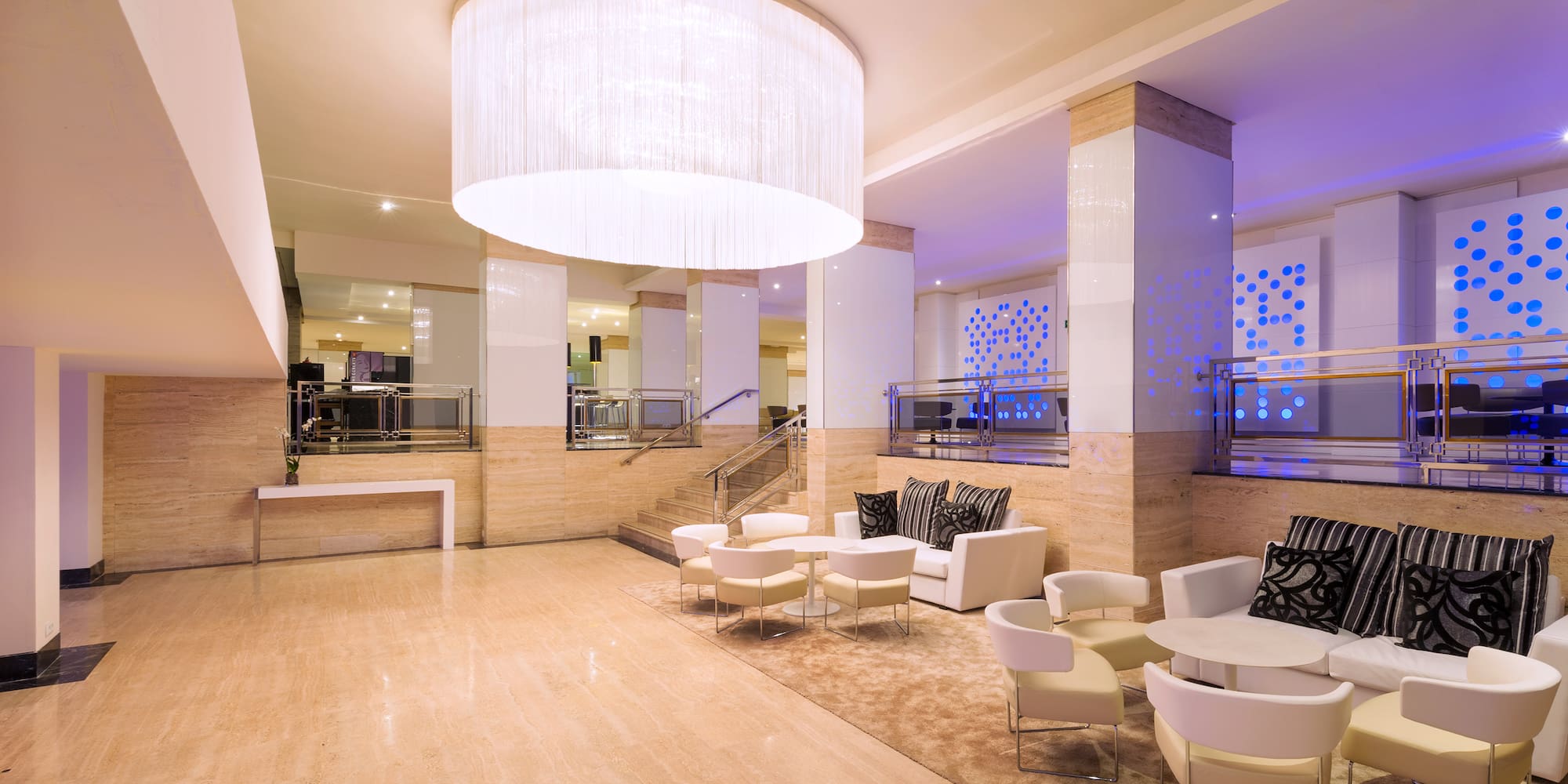 a room with white chairs and a chandelier