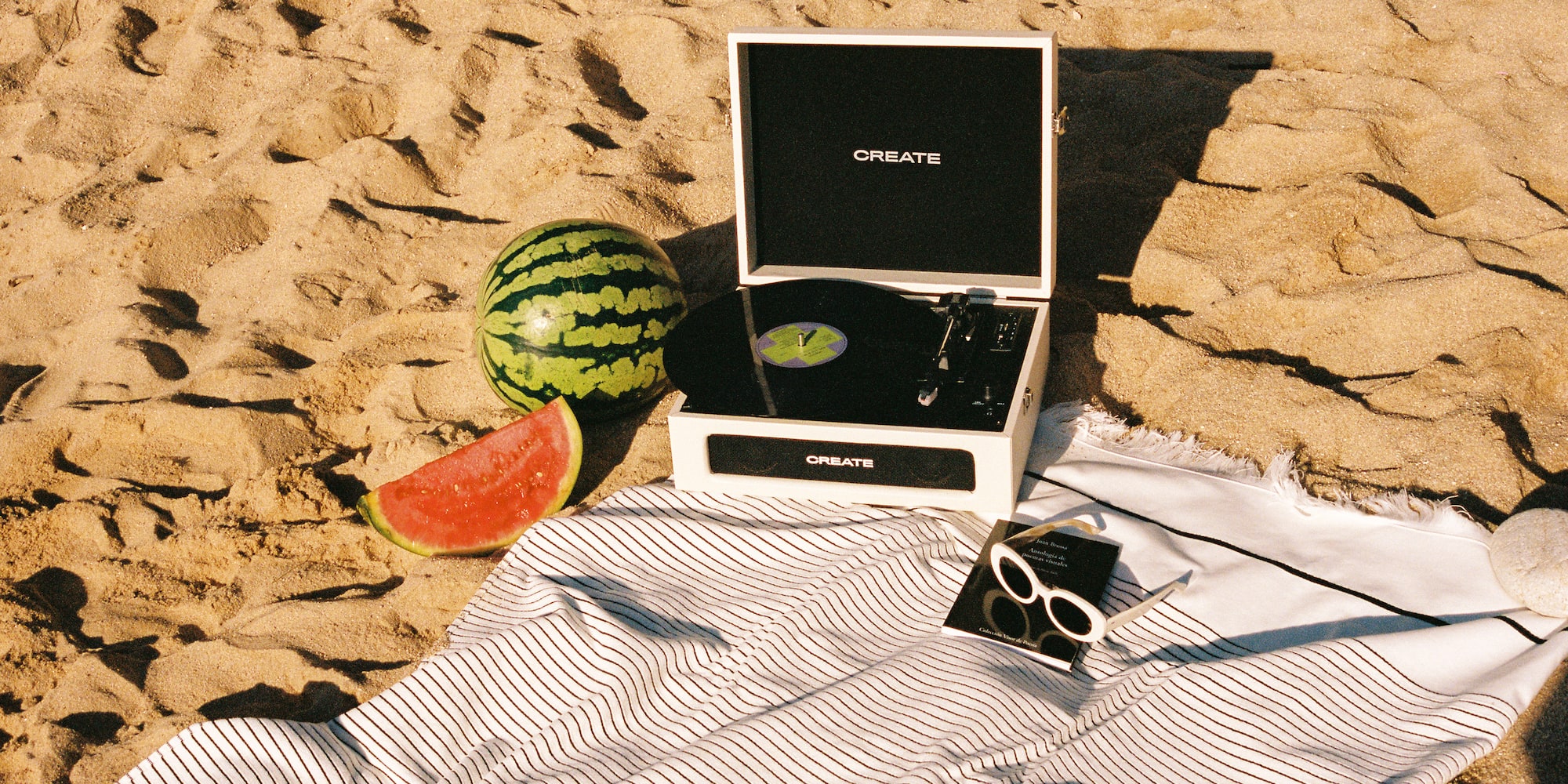 a record player and watermelon on a beach