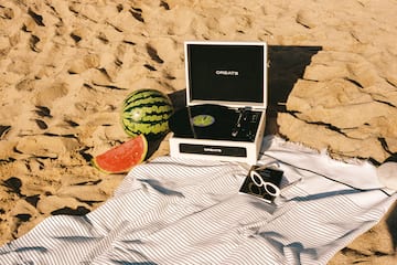 a record player and watermelon on a beach