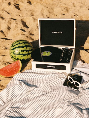a record player and watermelon on a beach