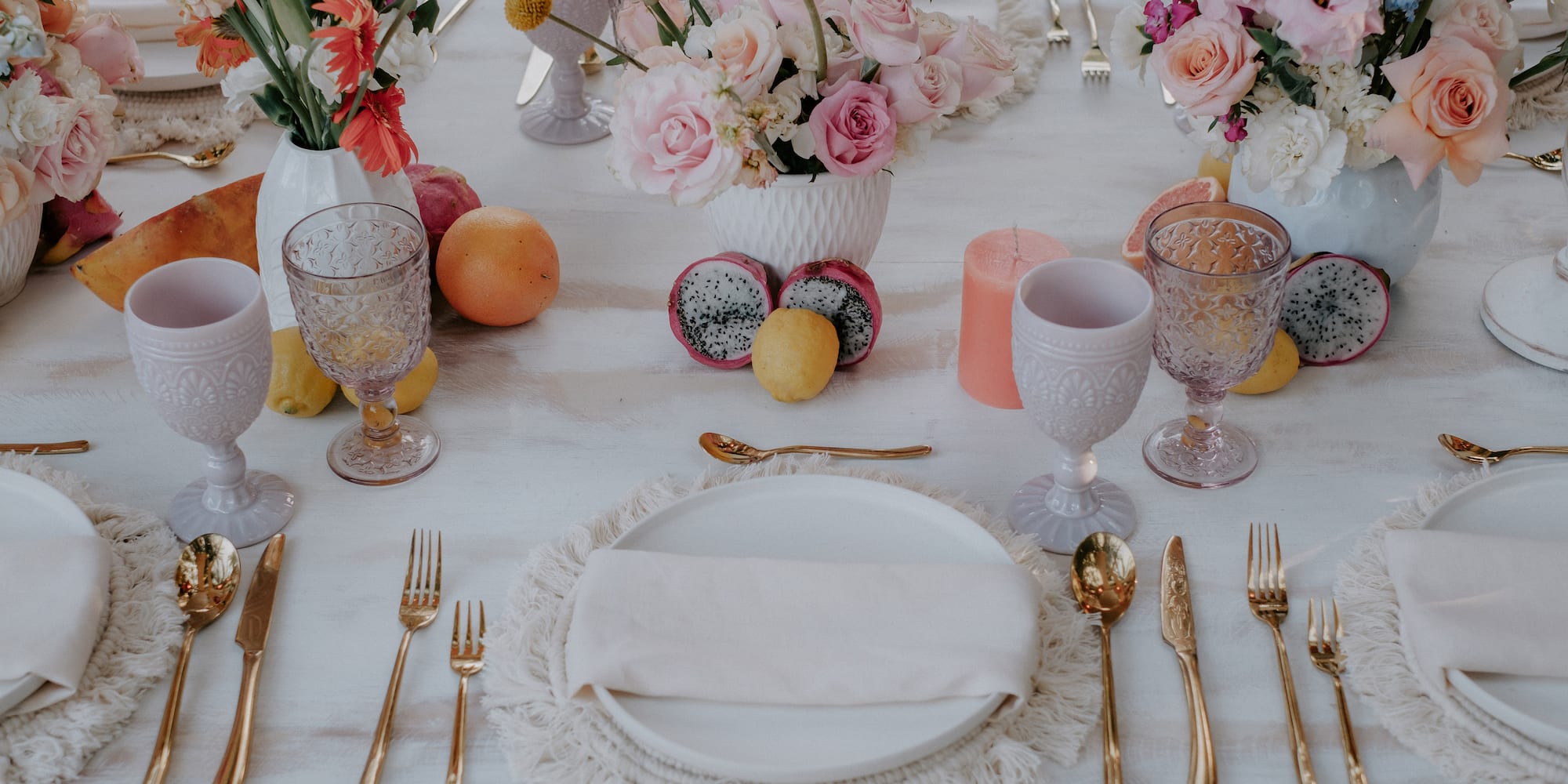a table with flowers and plates and glasses