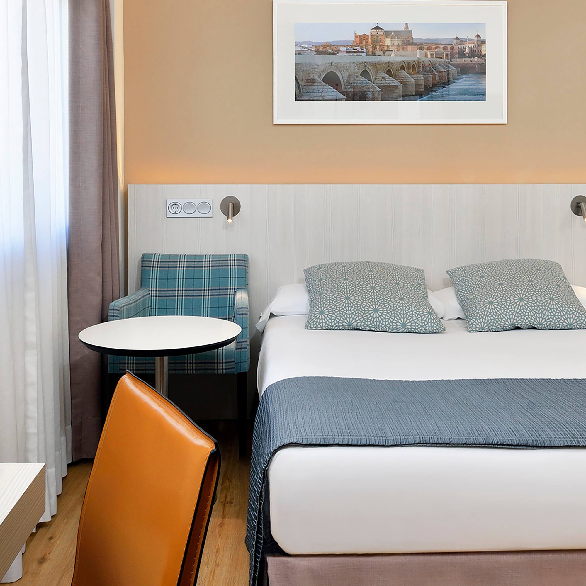 a bed with a chair and a table in a hotel room.