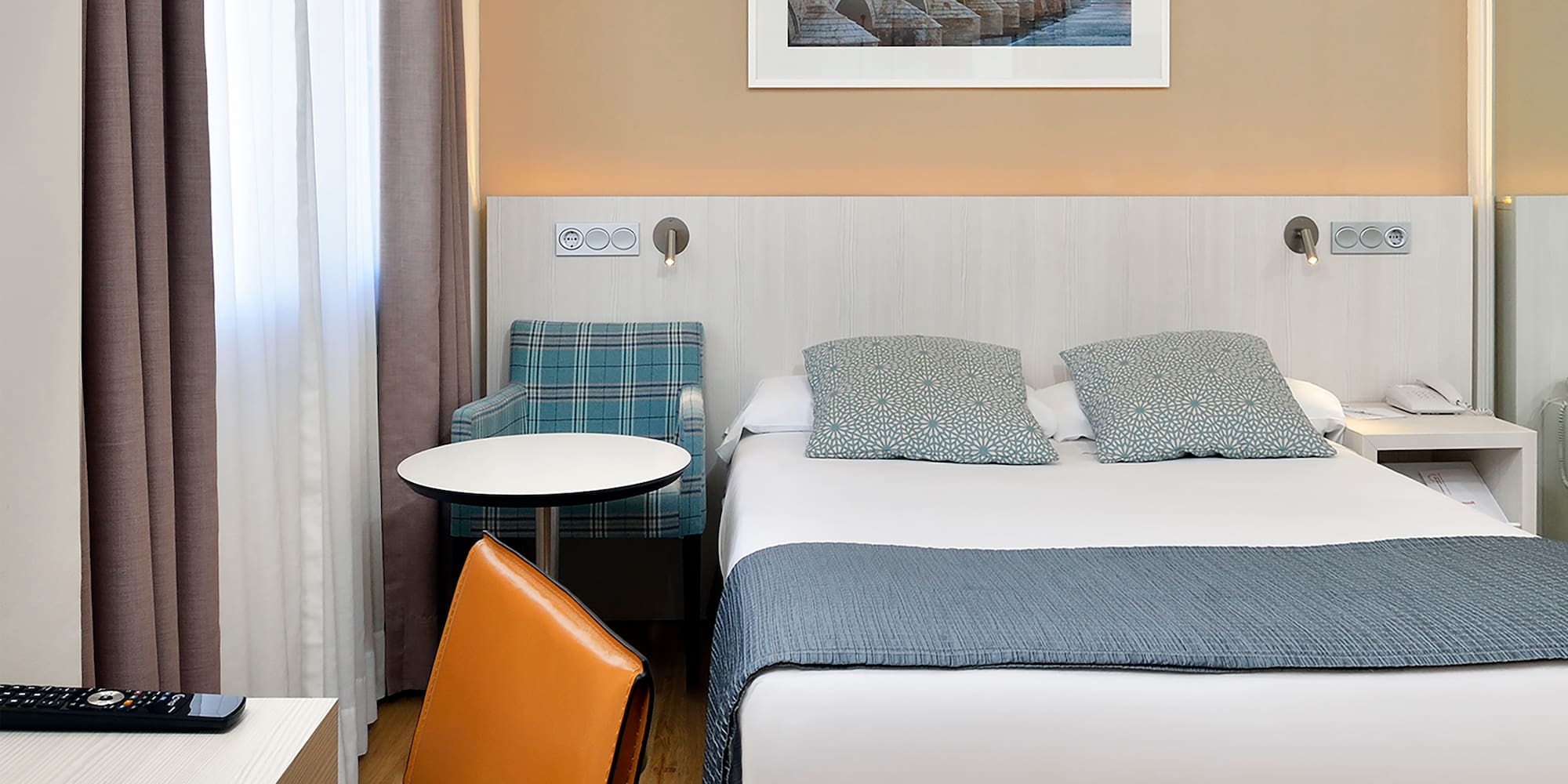 a bed with a chair and a table in a hotel room.