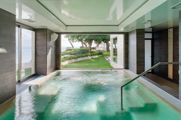 a pool with a staircase and a green lawn
