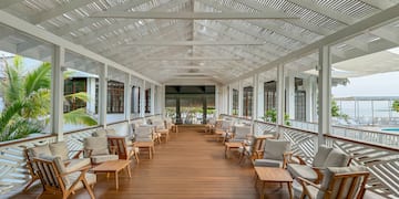 a large covered porch with chairs and tables