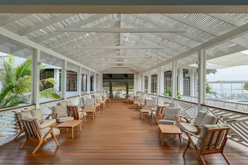 a large covered porch with chairs and tables