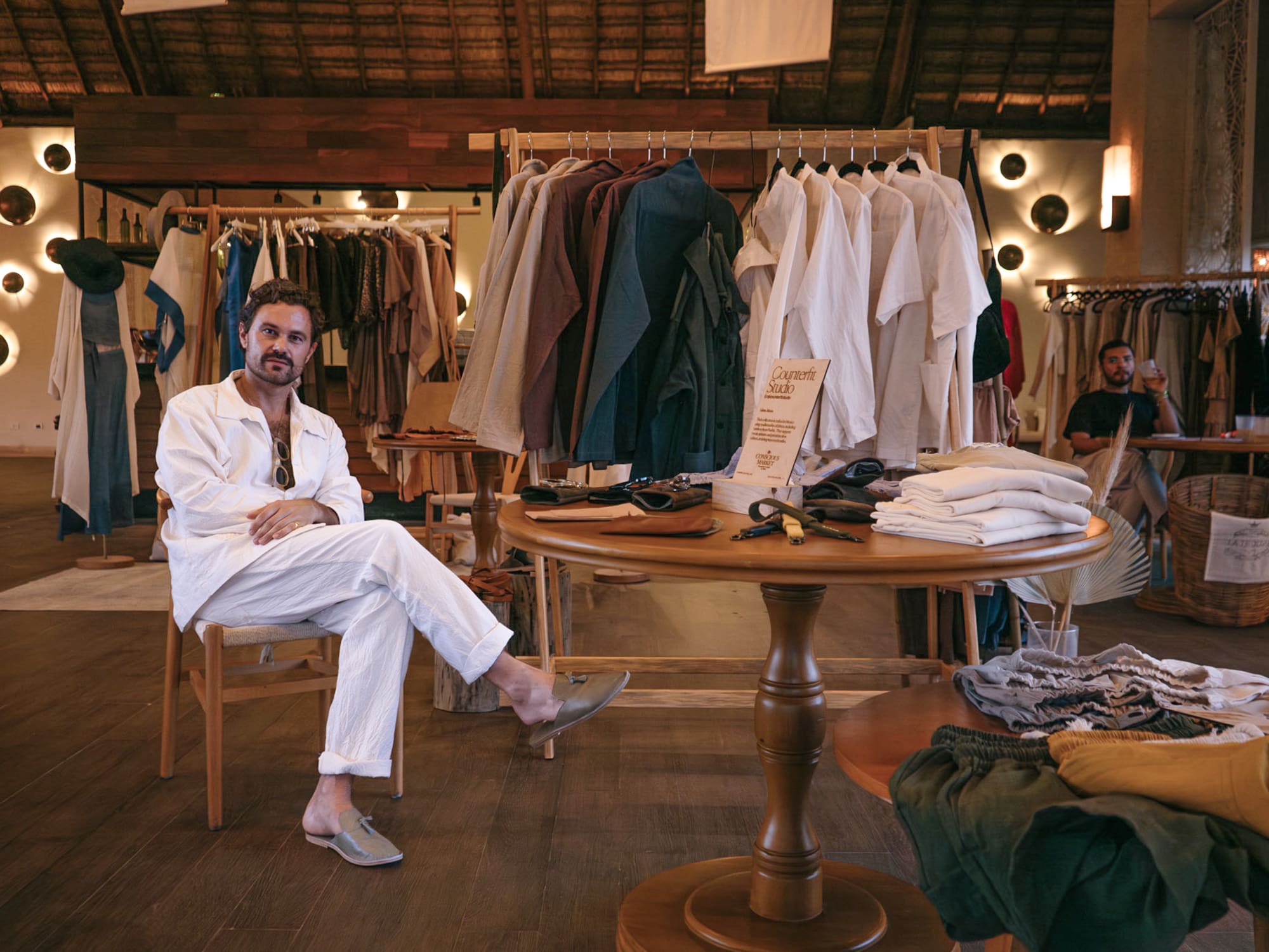 a man sitting at a table in a clothing store