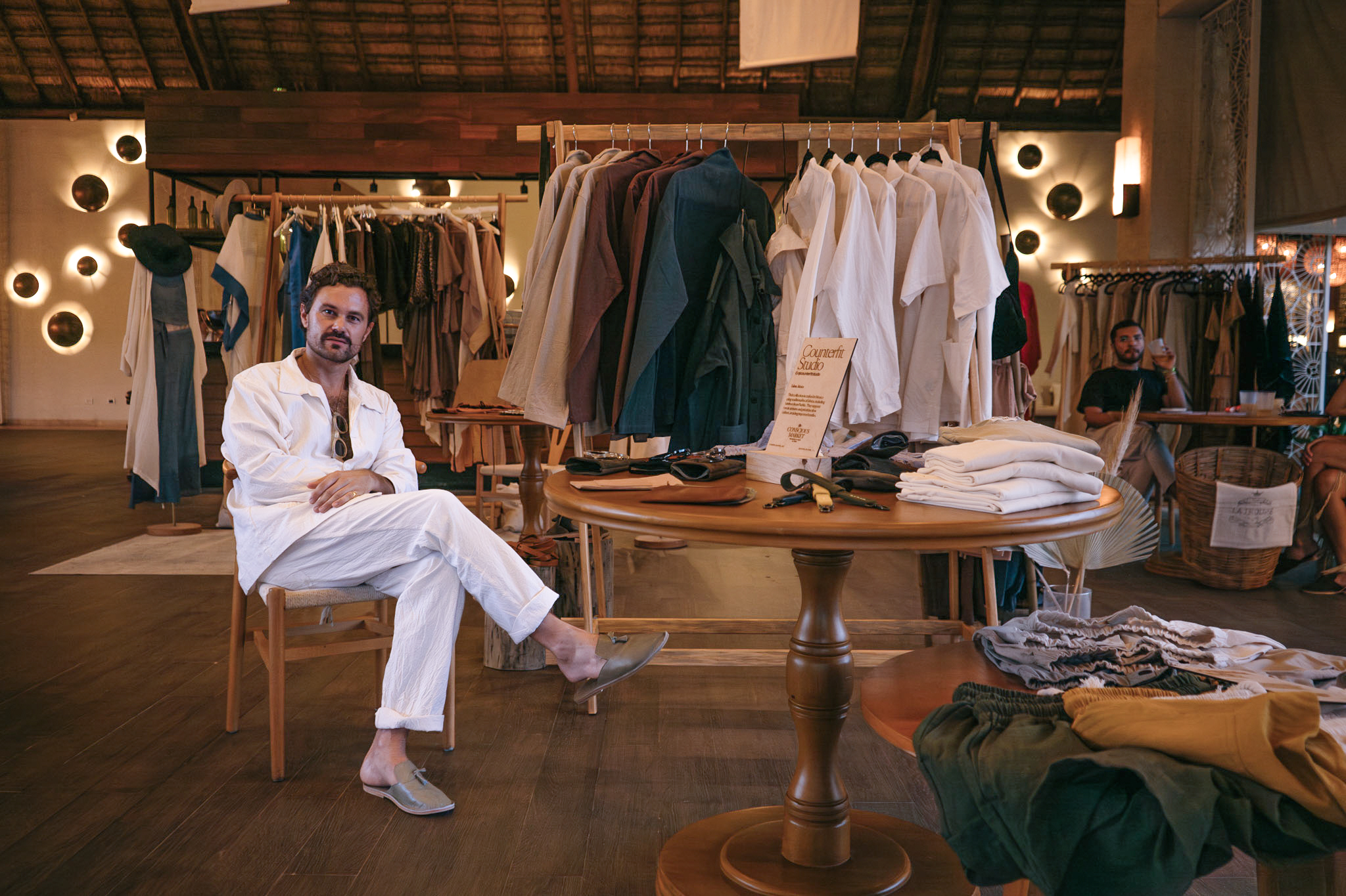 a man sitting at a table in a clothing store