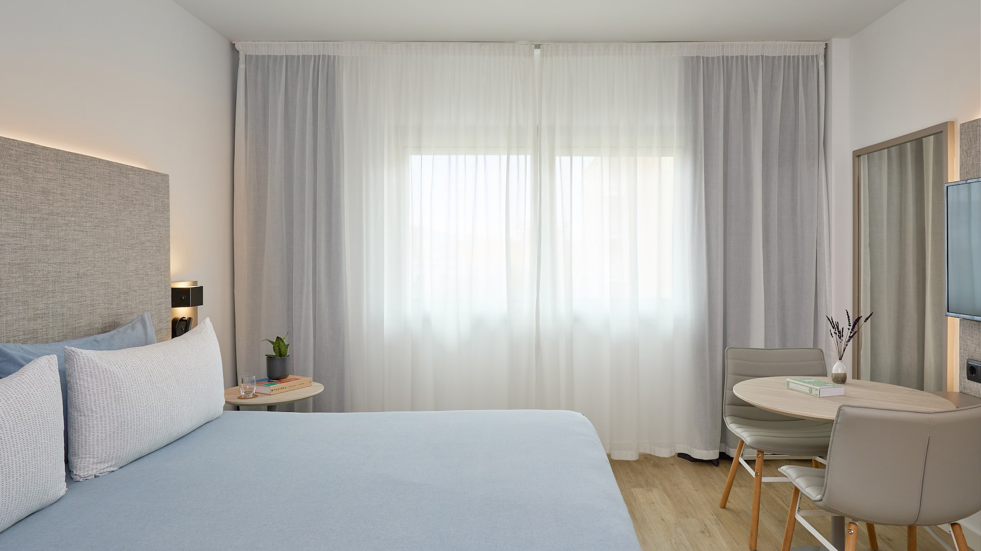 a bedroom with a bed and a table and chairs