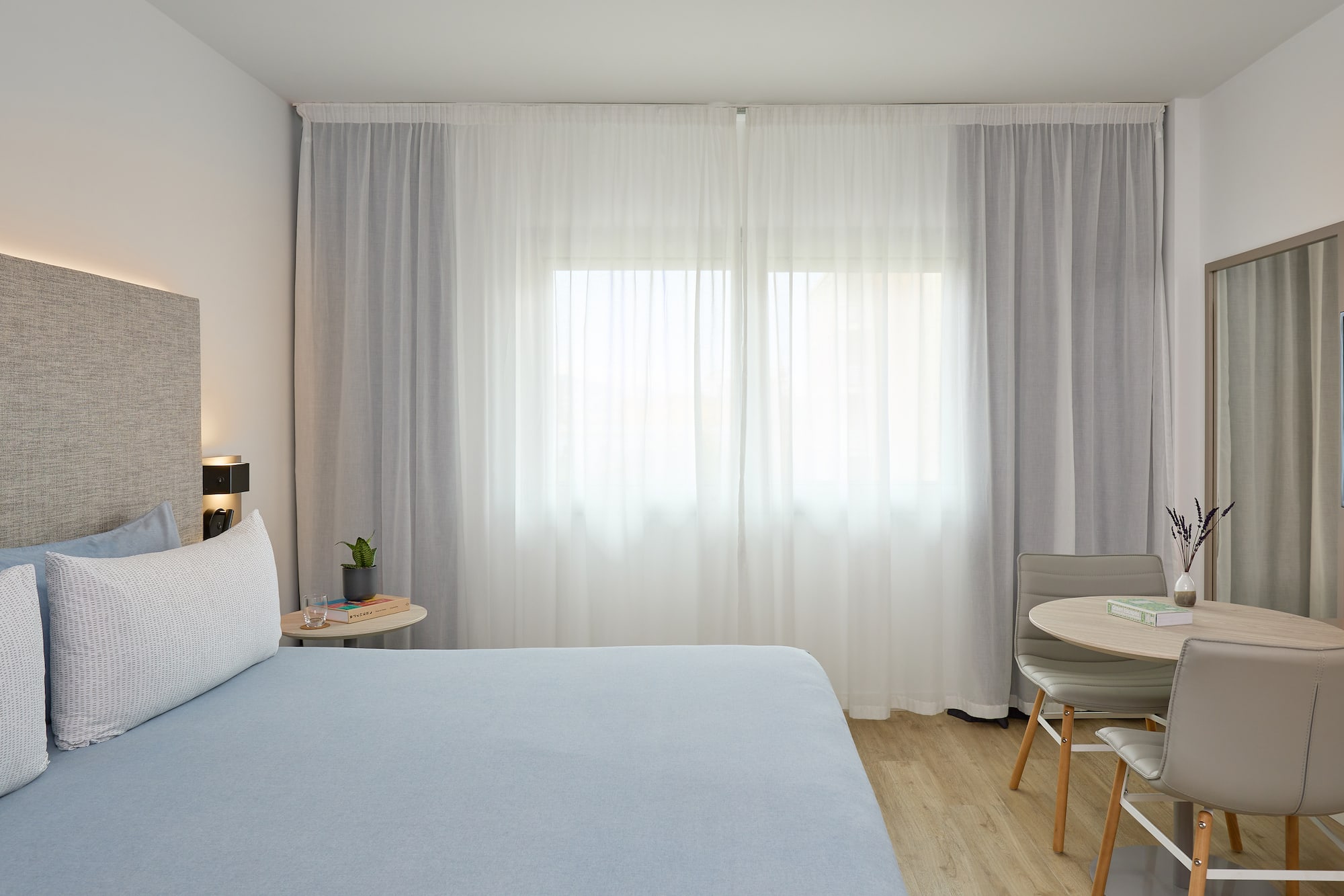 a bedroom with a bed and a table and chairs