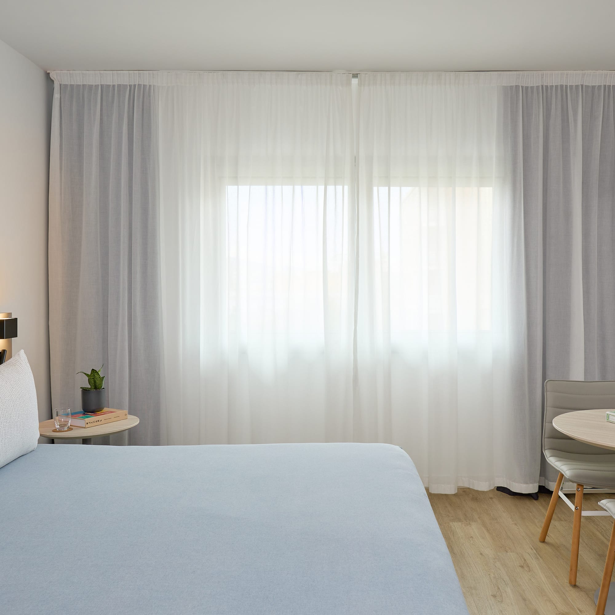 a bedroom with a bed and a table and chairs