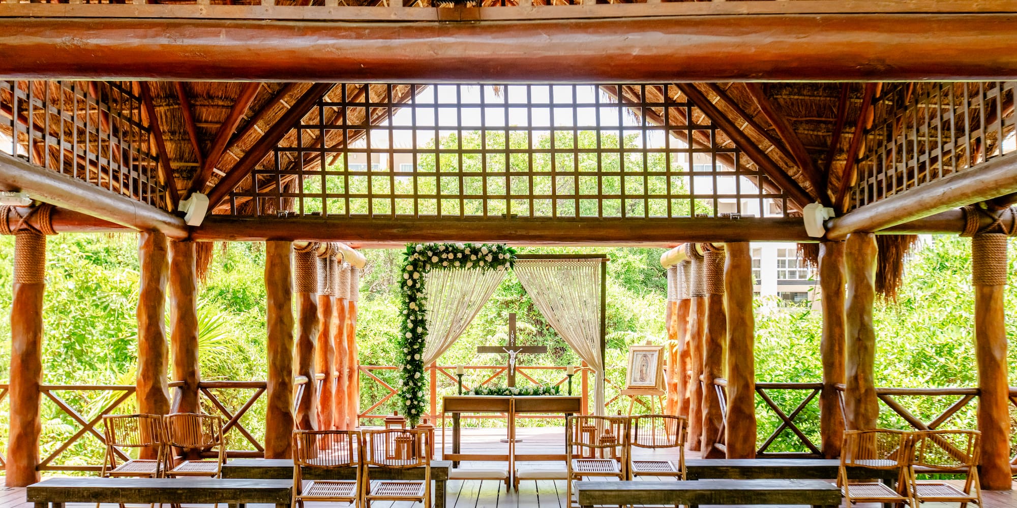 a wooden structure with a cross and chairs